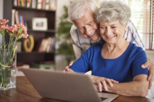 Couple de personnes âgées utilisant l'ordinateur